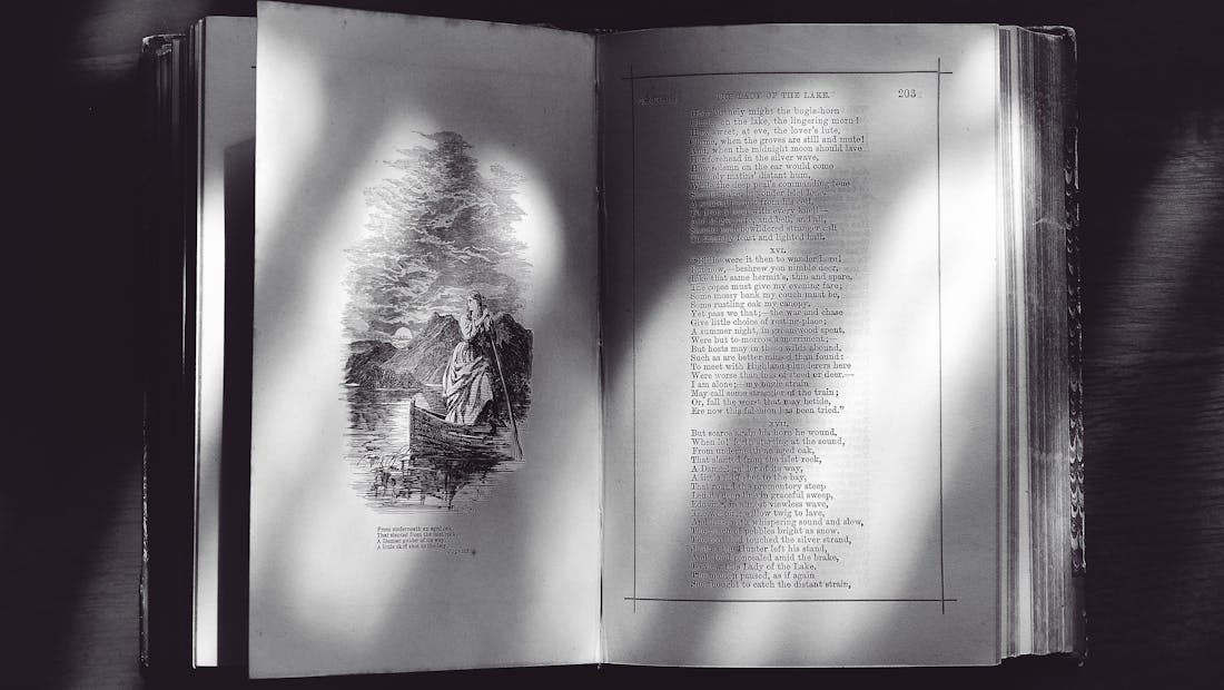 An old open book with handwritten text and an illustration